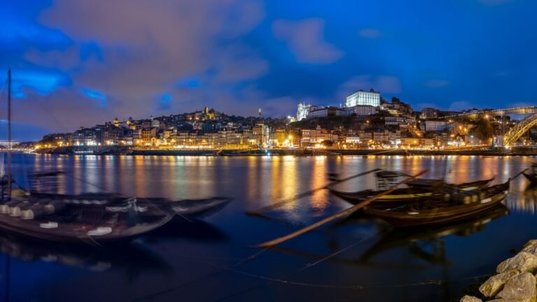 Panoramic view of Porto and the Dom Luis I bridge across the Douro river at blue hour.
