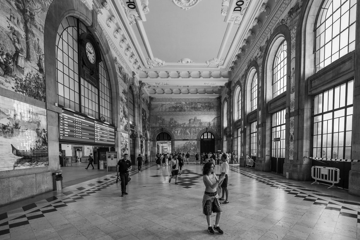 Black and white interior view of Sao Bento station hall with tile panels in Porto.