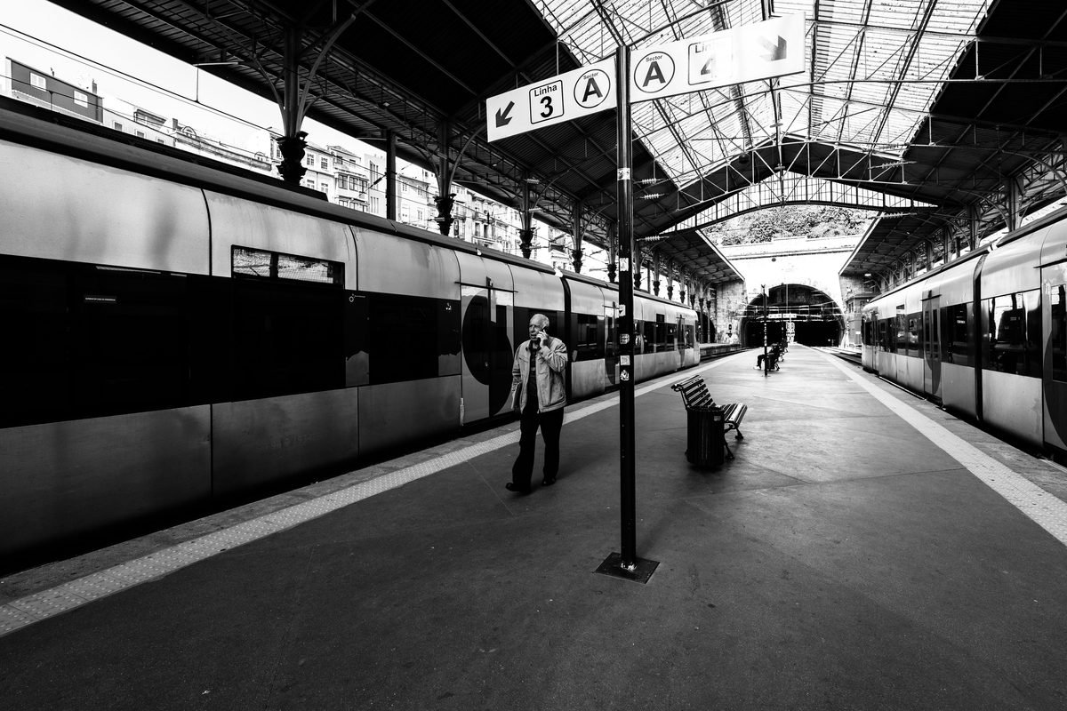 Man walking through the grand hall of Sao Bento train station in Porto.