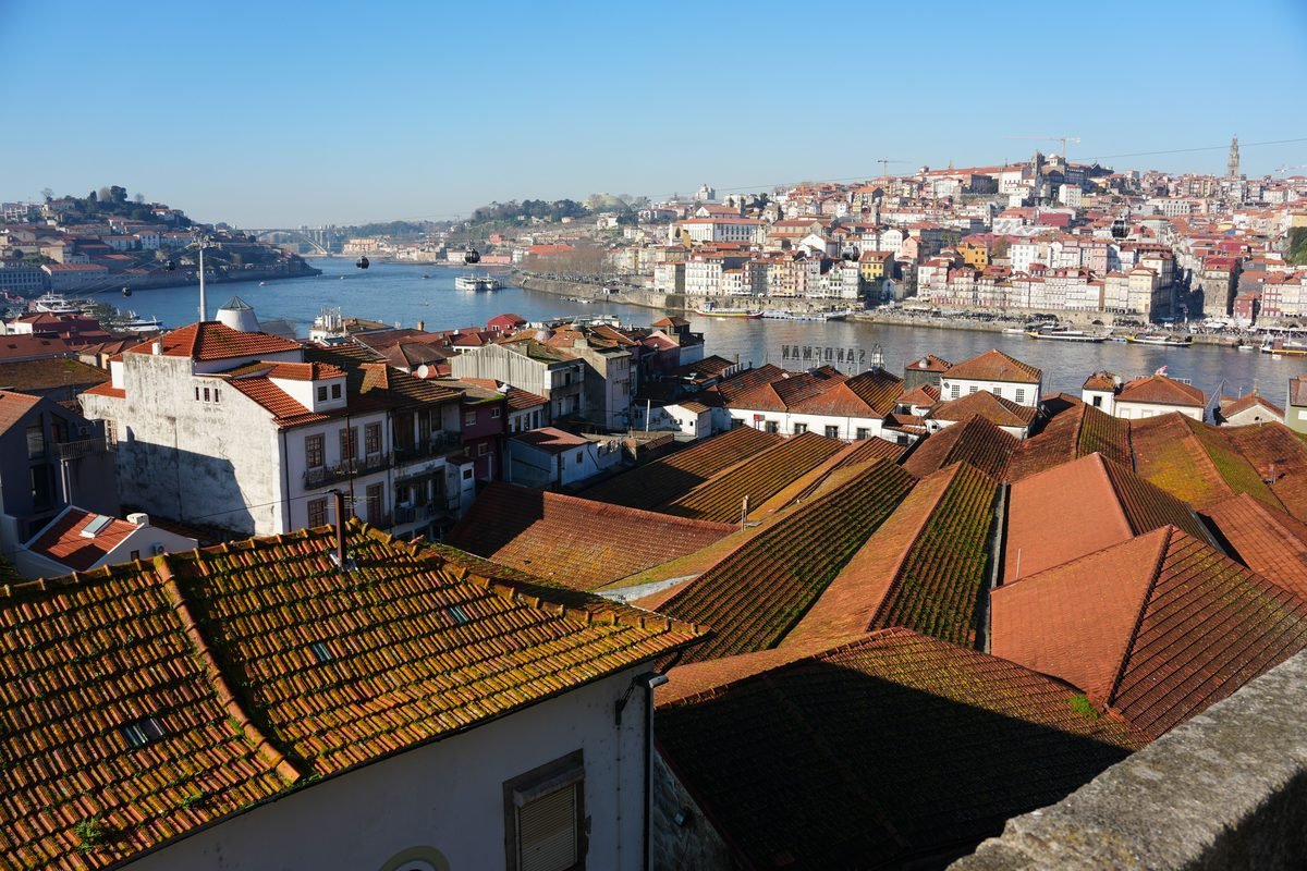 Terracotta rooftops leading down to the Douro river in Porto.