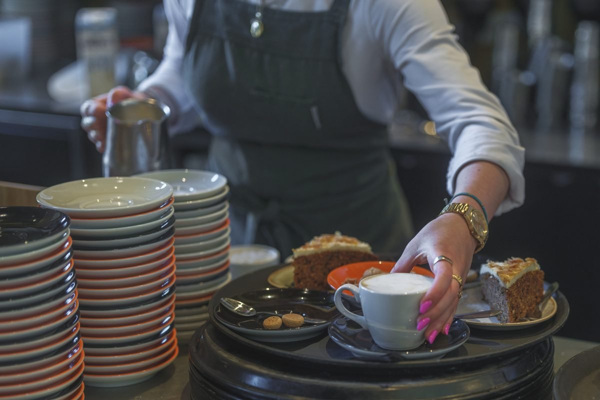 A slice of cake and a coffee cup at a café.