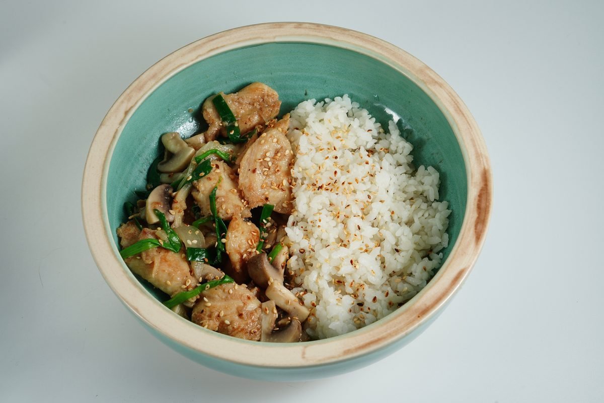 Savory chicken stir-fry with rice served in a ceramic bowl
