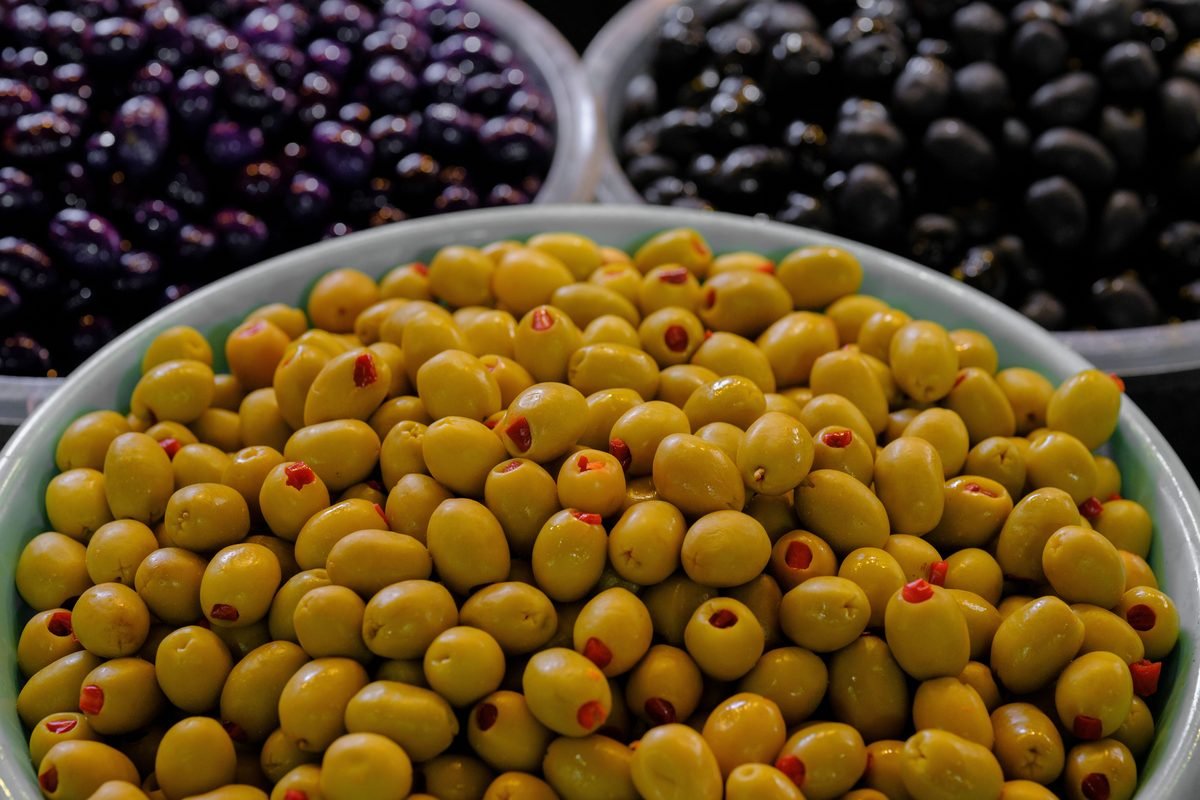 Bowls of green and black olives at a market