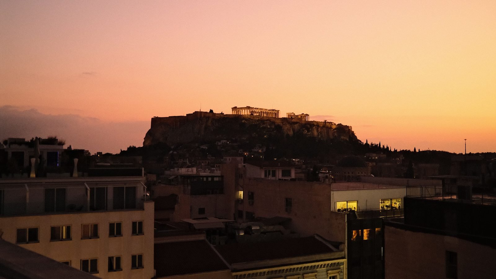 The Parthenon temple atop the Acropolis with the sun low in the sky