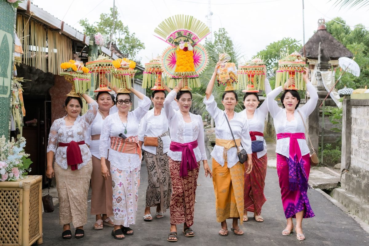 Balinese women in traditional attire carrying ceremonial offerings