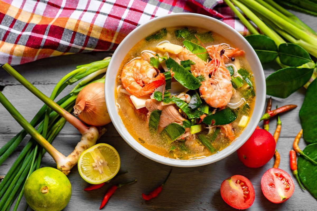 Bowl of Tom Yum soup with prawns and herbs