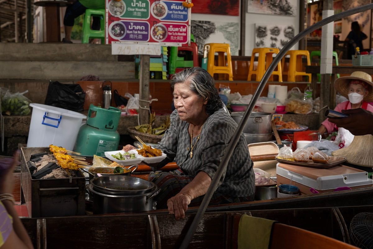 Vendor cooking skewers on a cart at a market