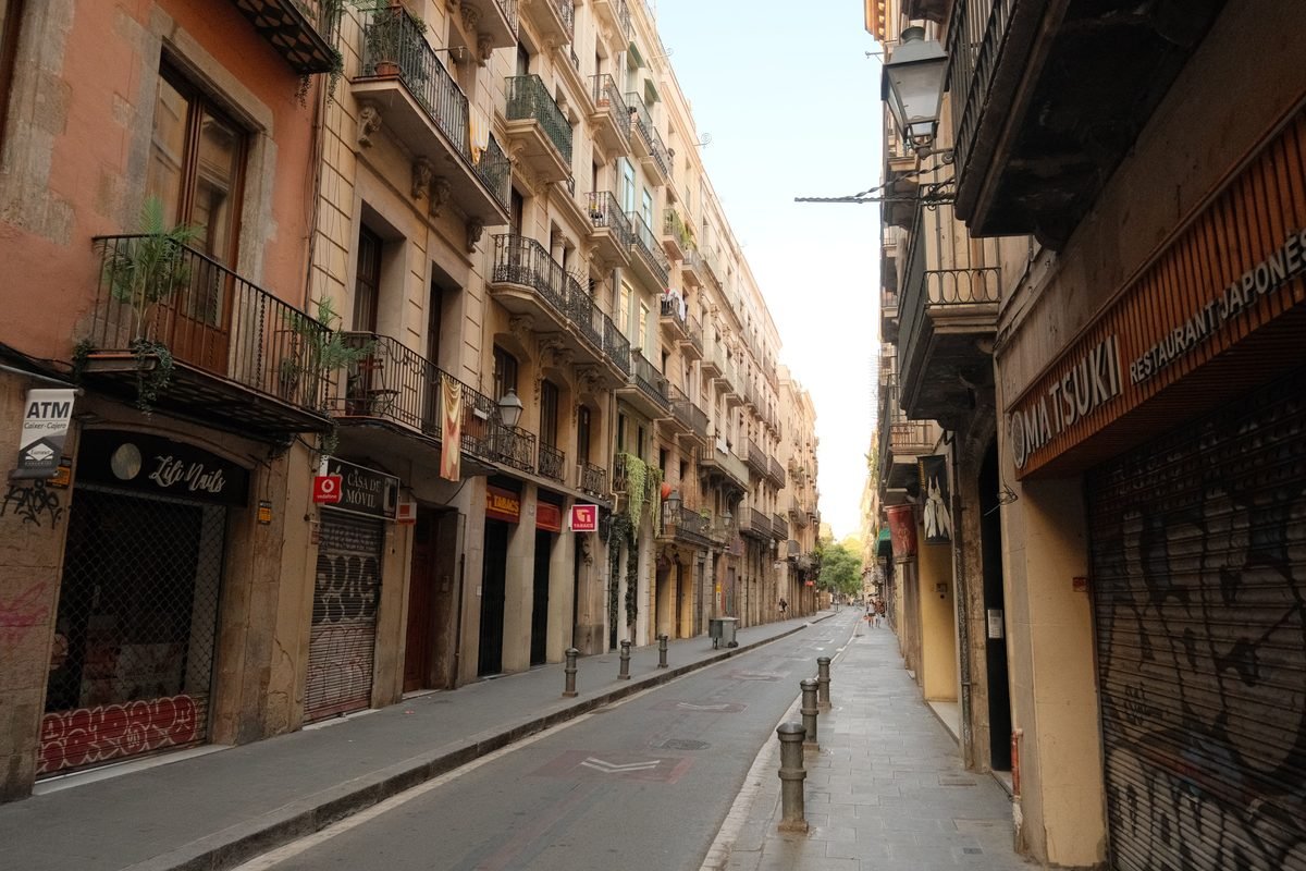 A quiet urban European street framed by traditional multi-story residential buildings.