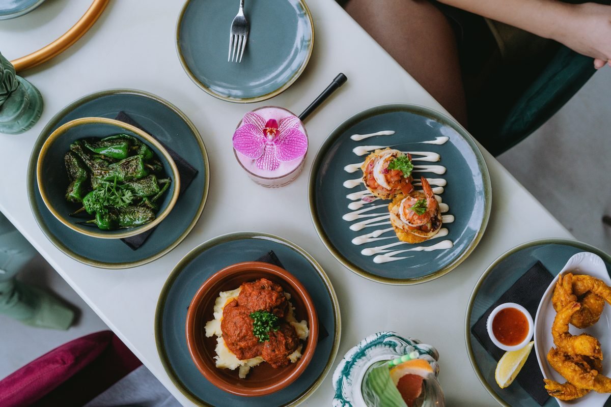 Top-down view of a dining table laden with assorted gourmet dishes and drinks.