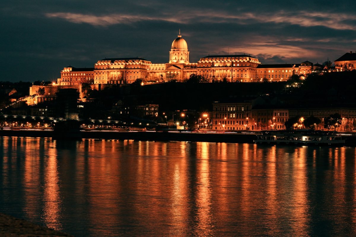 Buda Castle illuminated at night reflecting on the river