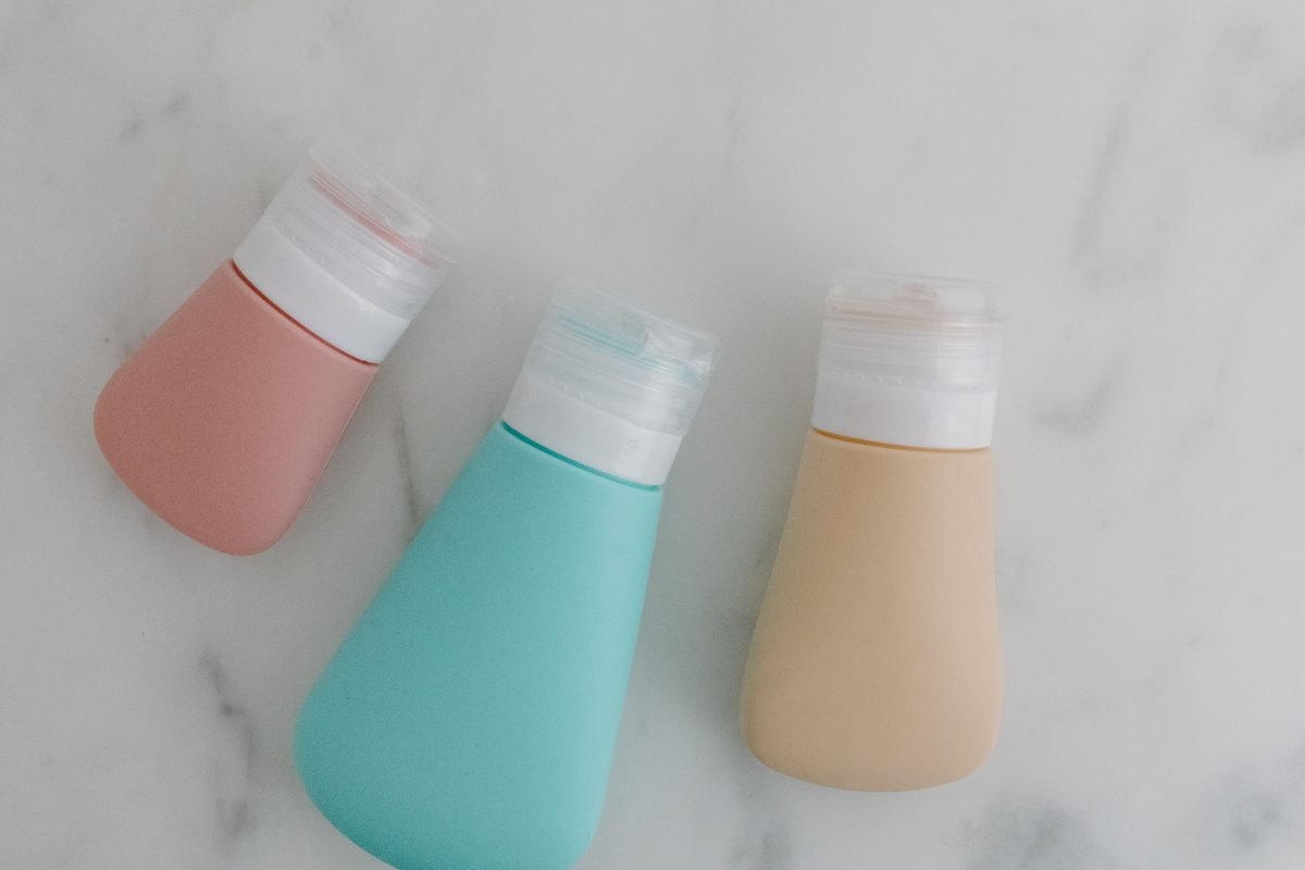 Colorful travel toiletry bottles on a flat surface