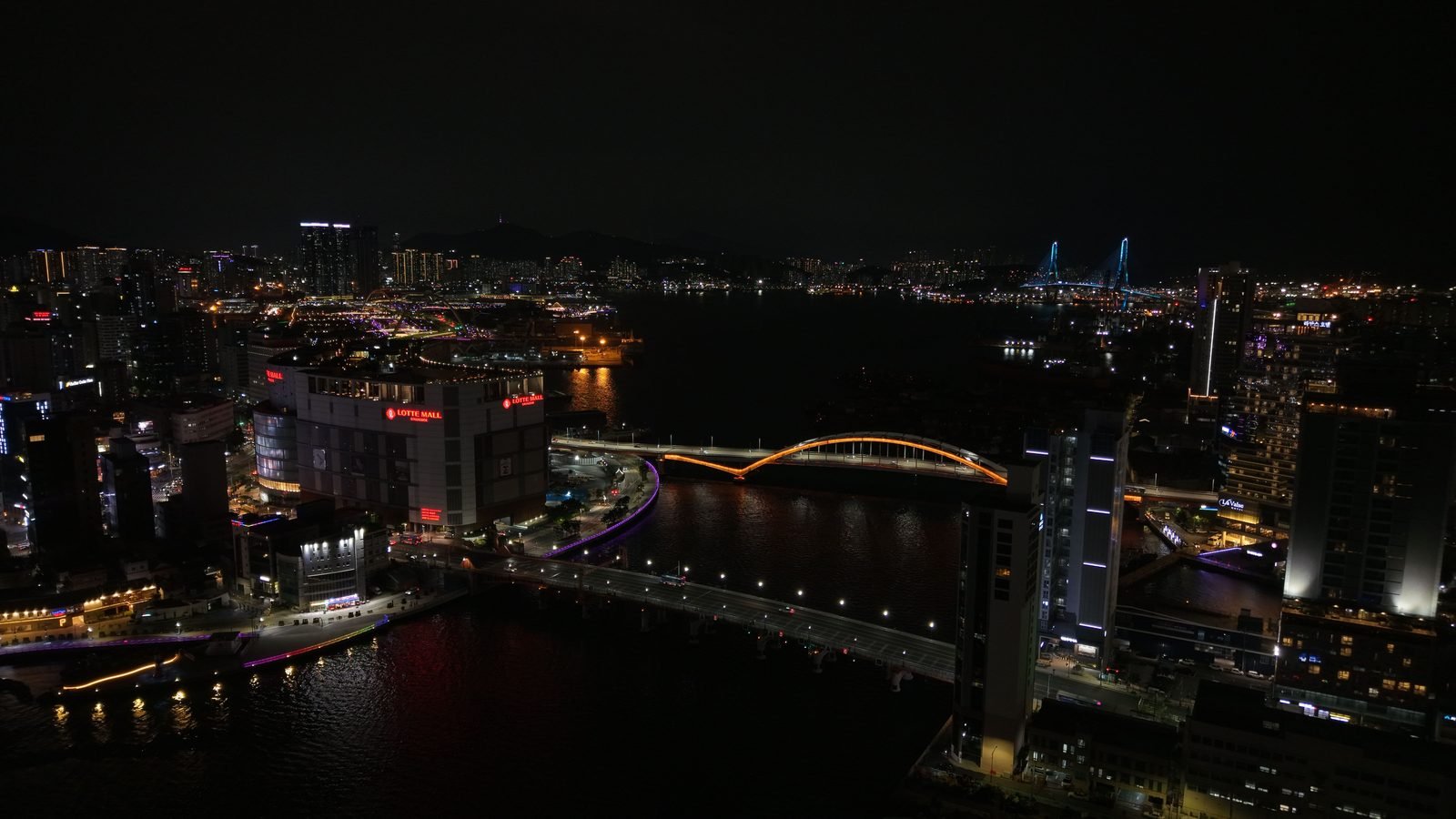 Panoramic nighttime view of Busan featuring the illuminated Gwangandaegyo Bridge and skyline
