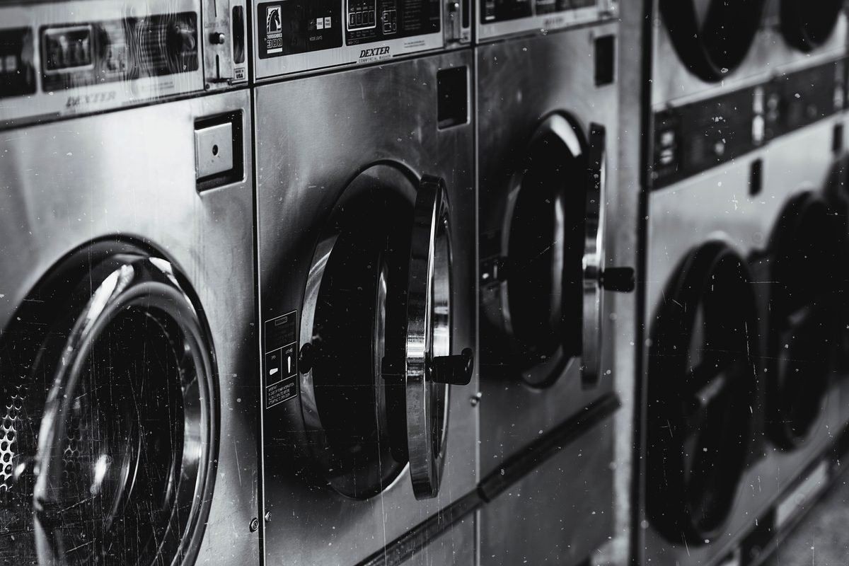 Black and white image of industrial washing machines in a retro facility