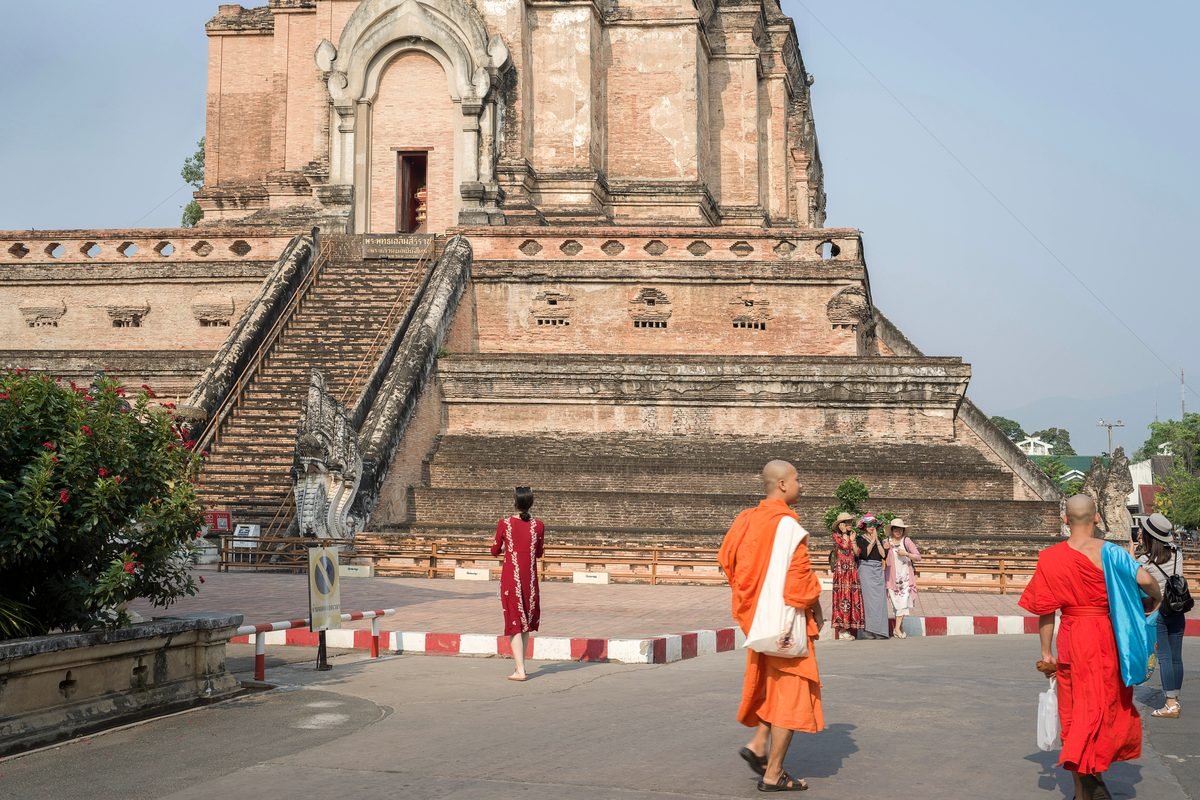 Monks and visitors walking near Wat Chedi Luang stupa in Chiang Mai