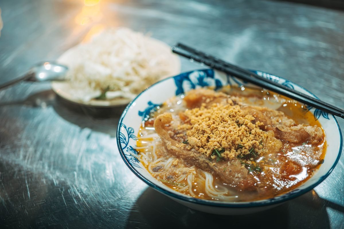Bowl of khao soi noodle soup with crispy topping