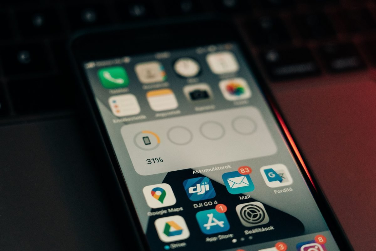 Smartphone screen showing battery level and app icons on keyboard.