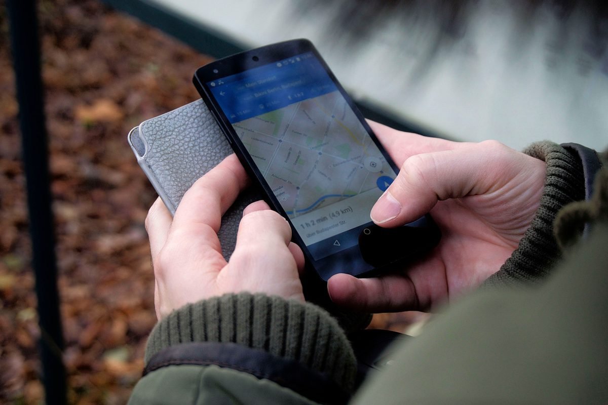 Close-up of hands using a mobile navigation map application.