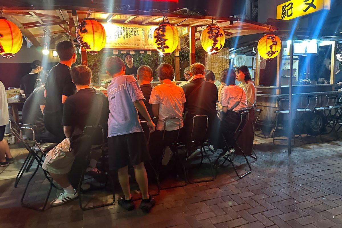 Customers dining at a yatai food stall at night in Fukuoka.