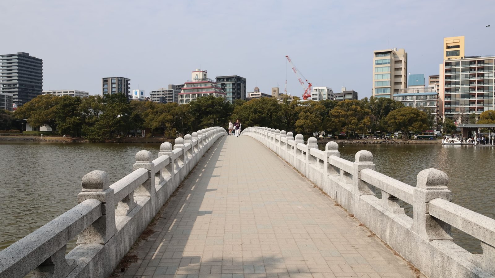 Stone pedestrian bridge over a river in Fukuoka.