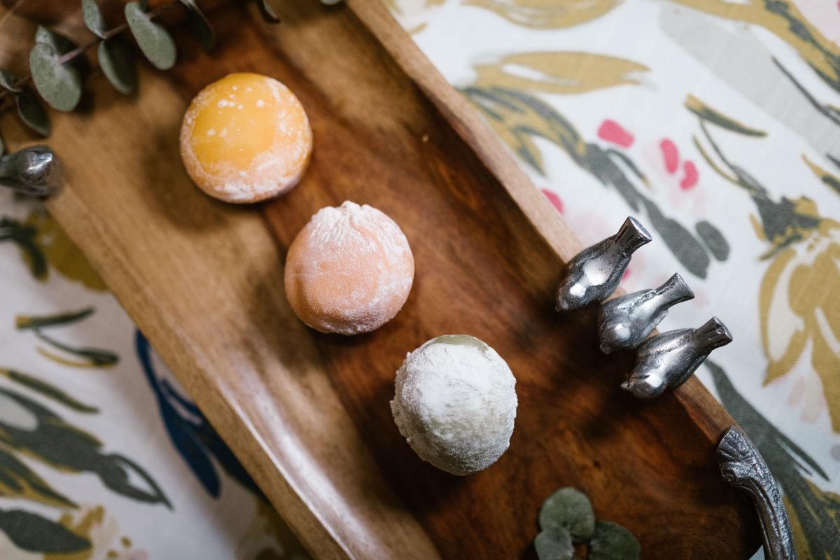 Assortment of colorful Japanese mochi desserts on a wooden tray.