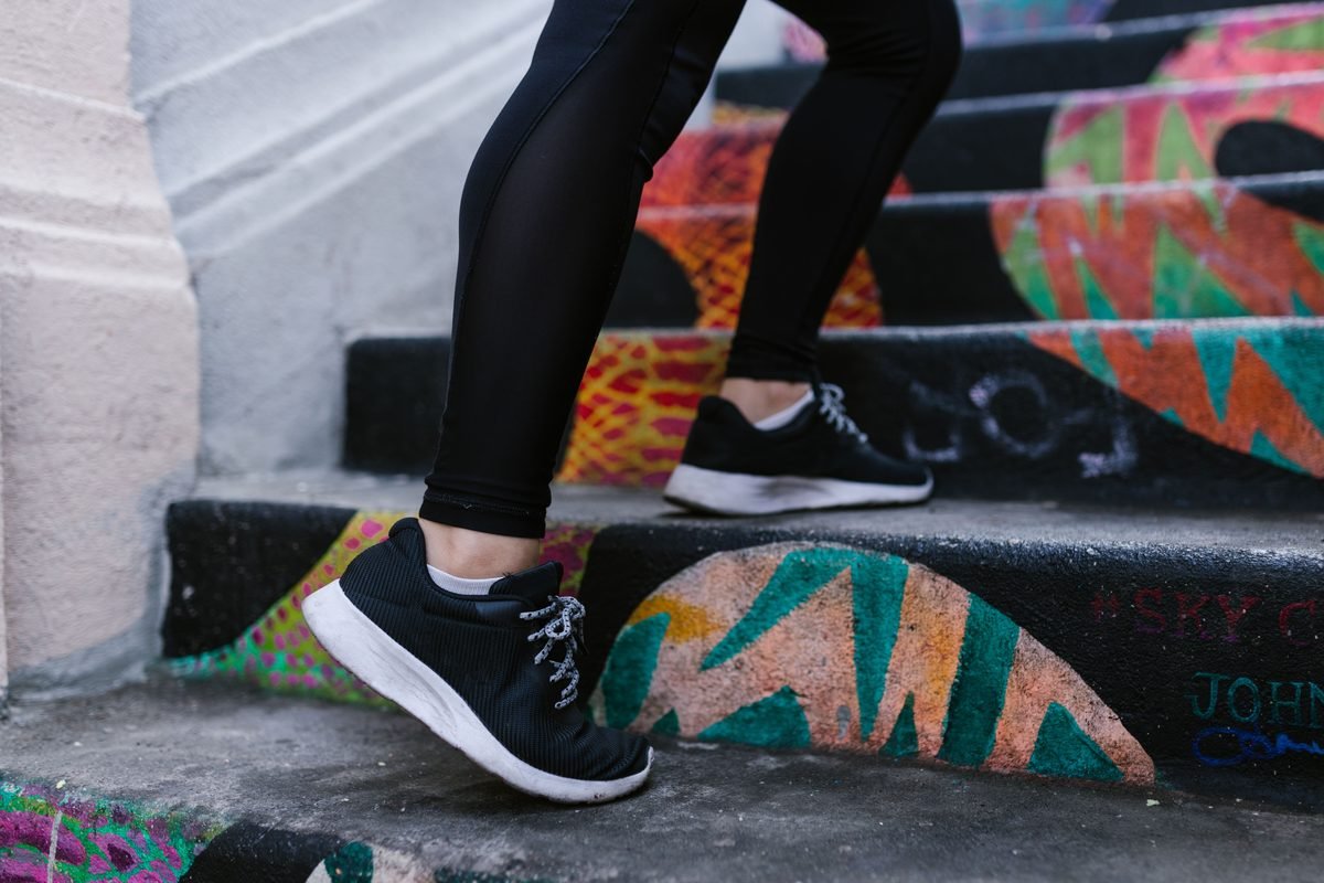 Person walking up colorful graffiti stairs wearing sneakers