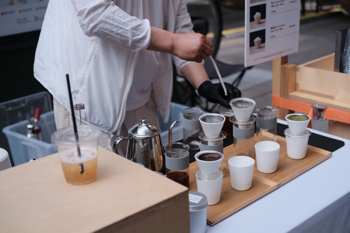 Barista preparing pour-over coffee at an outdoor setup