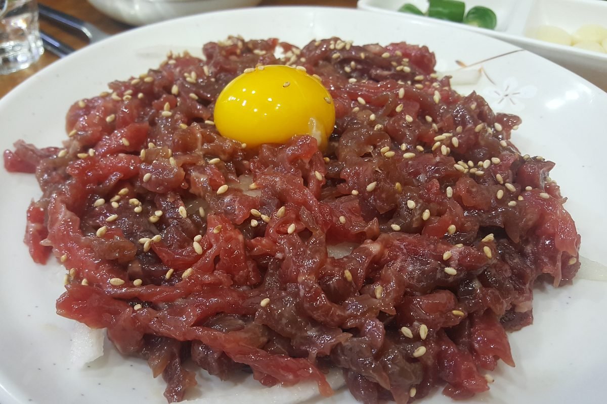 Plate of yukhoe, seasoned raw beef topped with a raw egg yolk, at Gwangjang Market in Seoul
