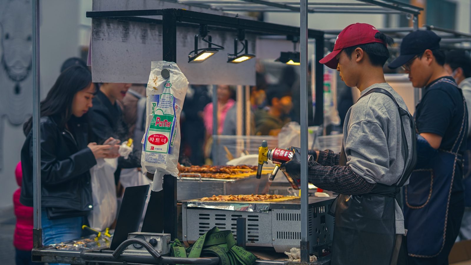 Street food vendor cooking at a bustling market in Seoul
