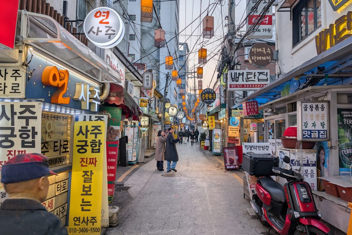 Bustling evening street in Seoul with traditional signage