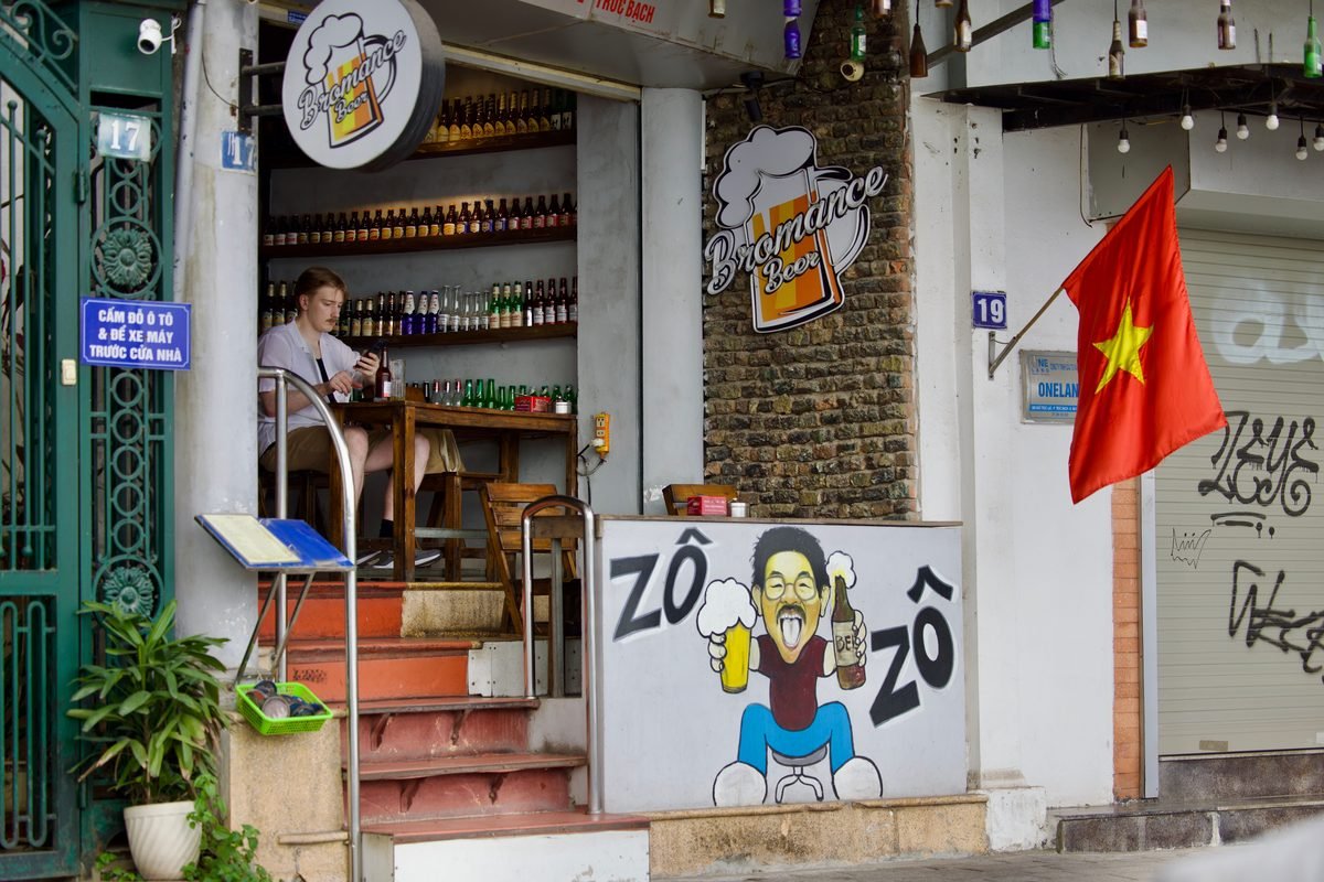 Cozy local beer bar storefront with a Vietnamese flag and outdoor seating