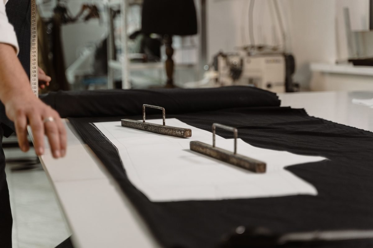 Tailor measuring fabric on a table in a clothing workshop