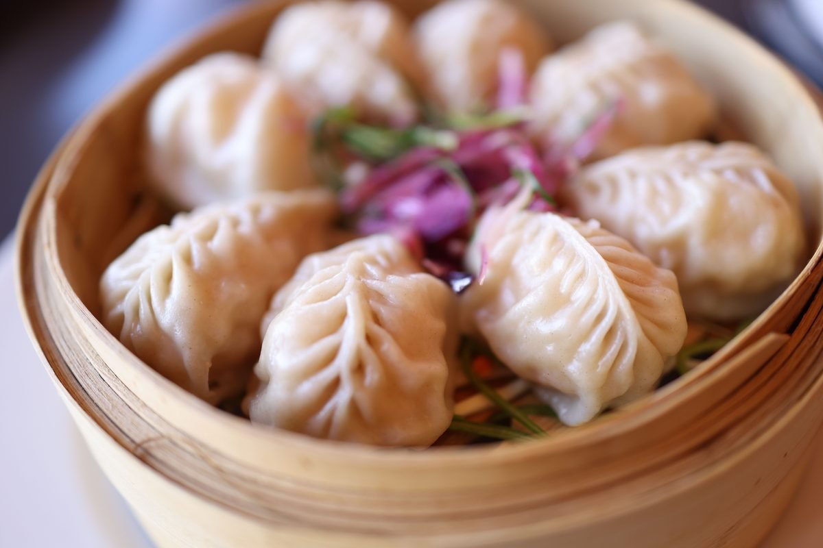 Steamed dumplings in a bamboo basket.