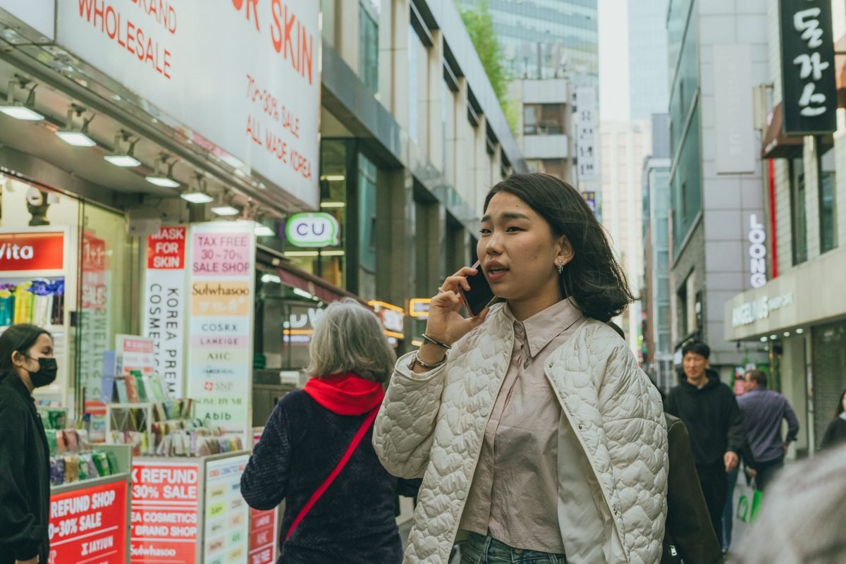 A bustling street scene in Seoul with people shopping and walking.