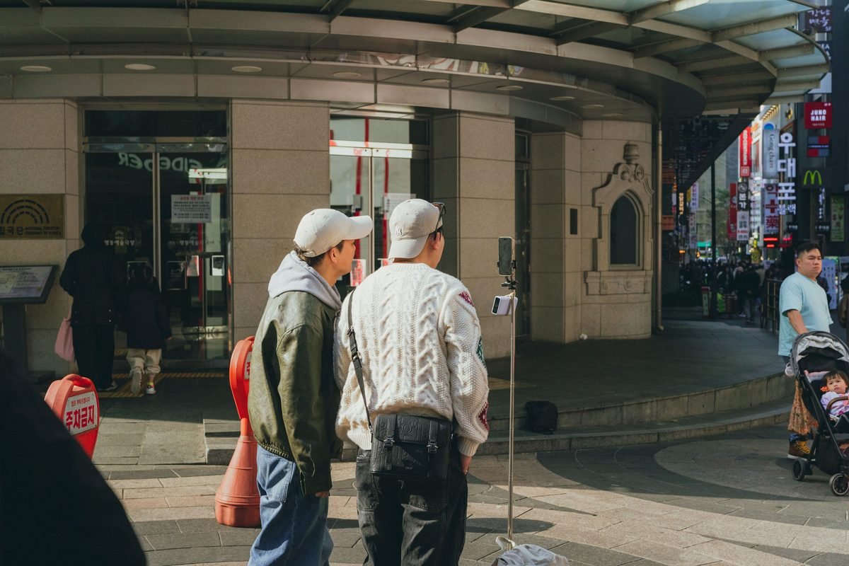 People standing outside a building in Seoul with street scenery
