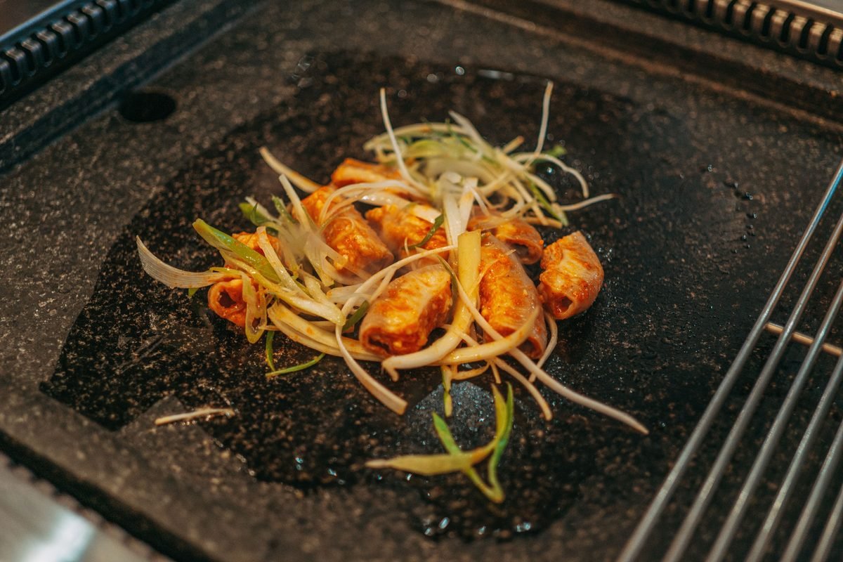 Korean meat and vegetables cooking on a hot stone grill