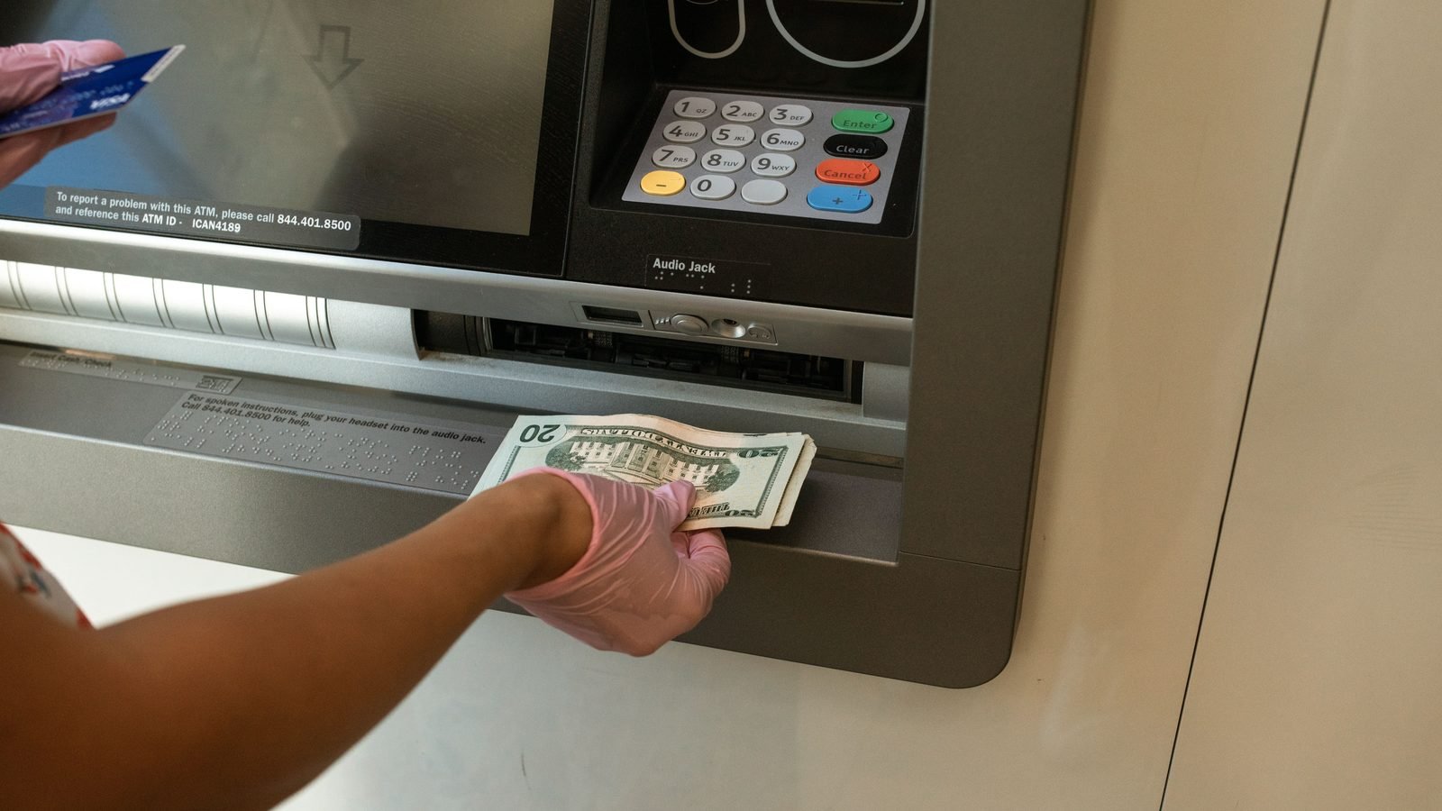Person withdrawing cash from an ATM machine