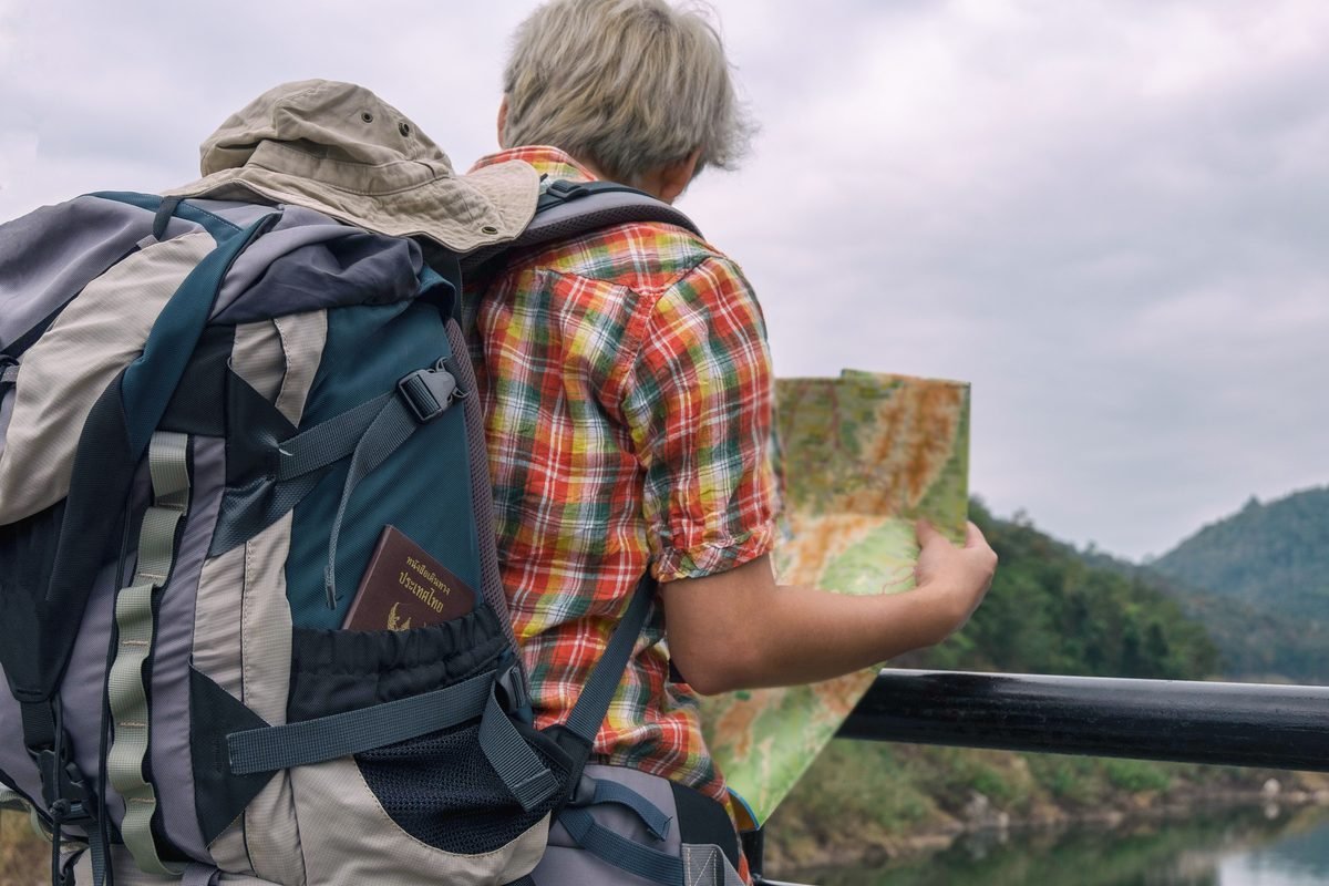Backpacker examining a map outdoors with backpack pocket visible