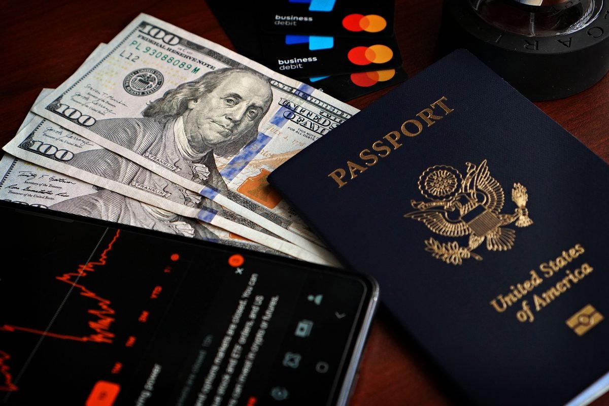 US passport, cash, and debit cards on wood table