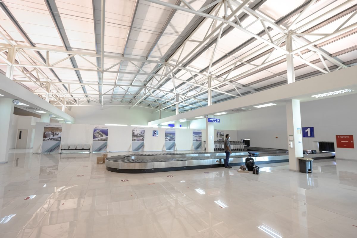 Modern airport baggage claim area with a traveler