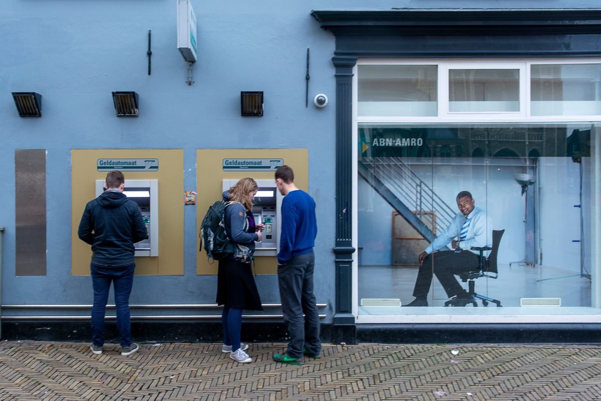 People using street ATMs outside a bank branch