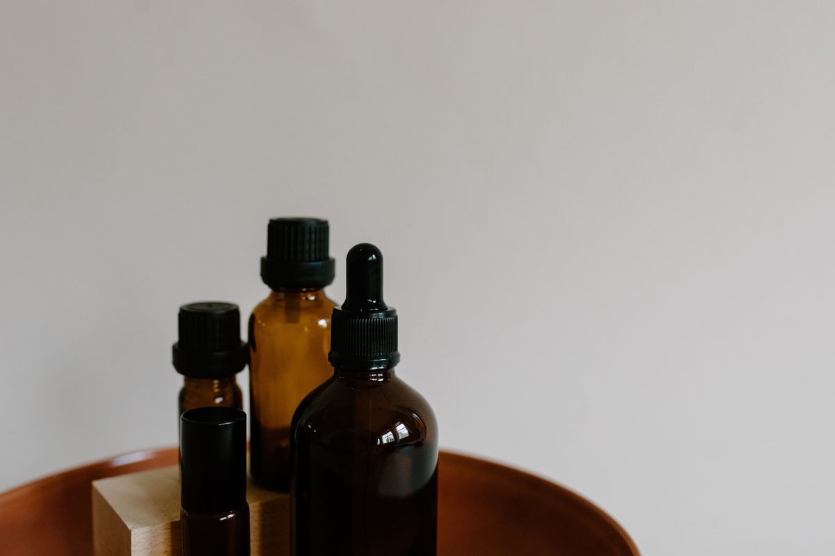 Minimalist arrangement of amber essential oil bottles on a tray.