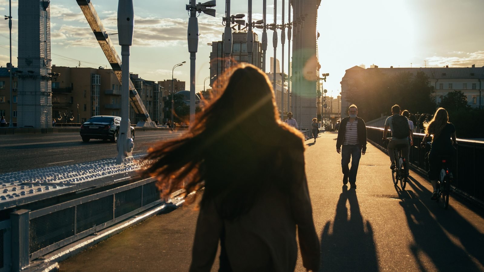 Silhouetted pedestrians enjoying an evening walk during sunset.