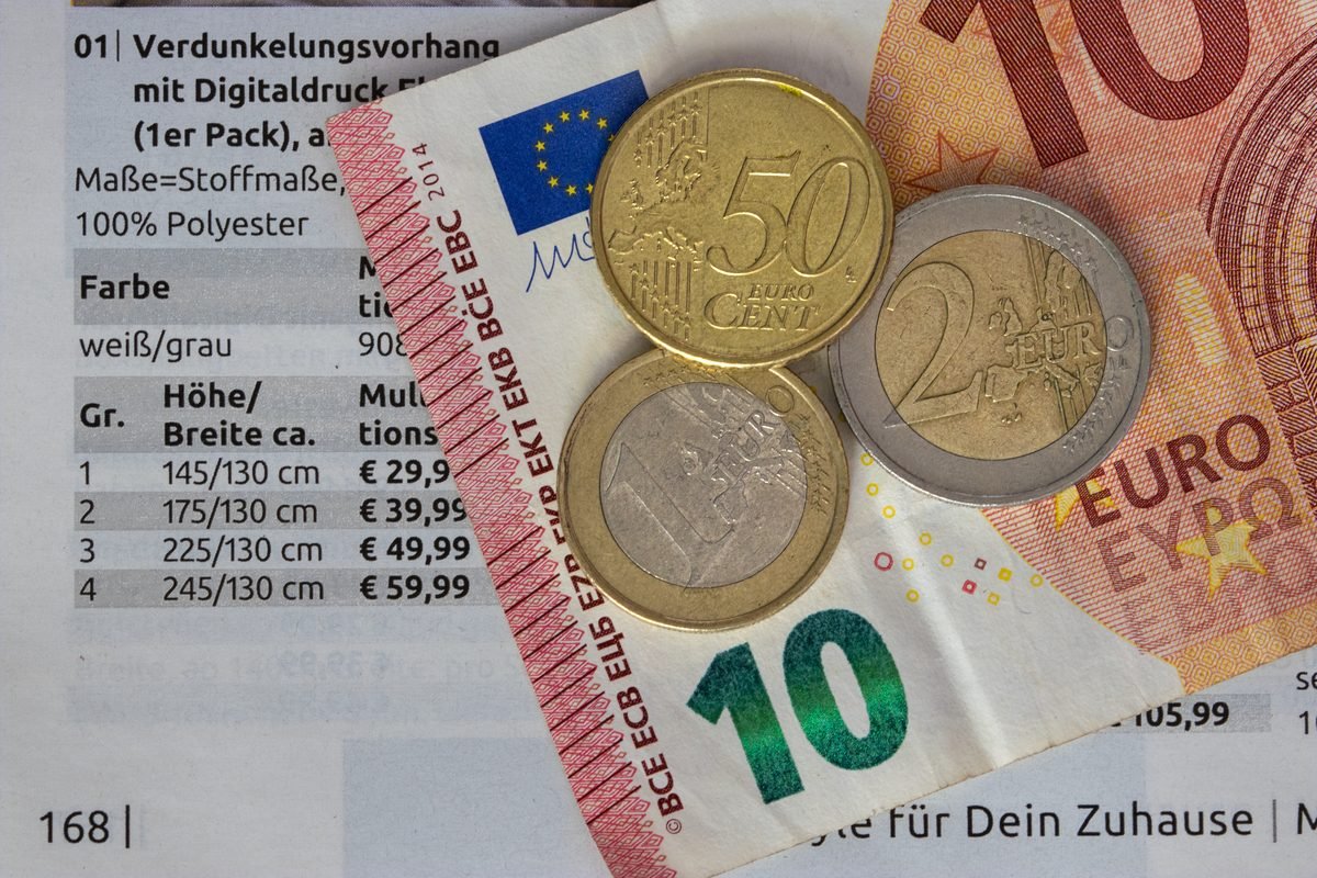 Euro banknotes and coins scattered over a printed financial document.
