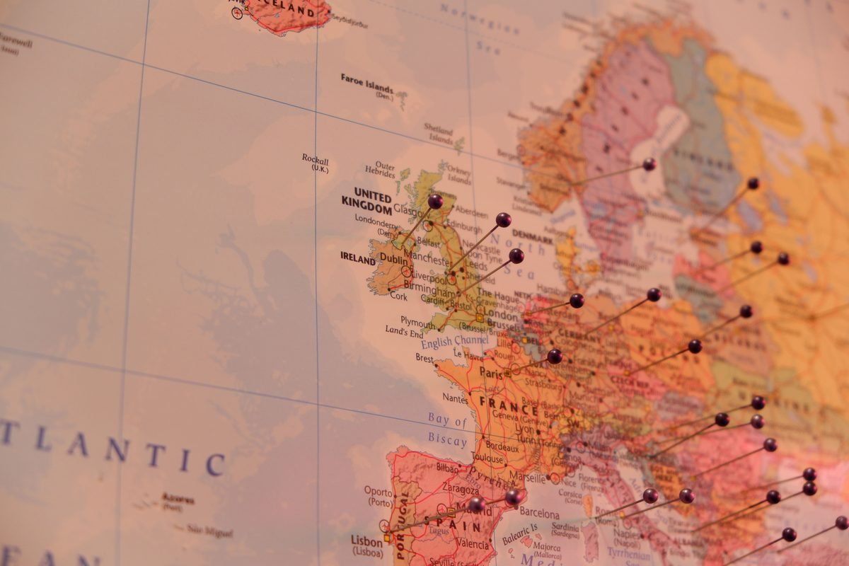 Close-up of a wall map with pins marking various destinations across Europe.
