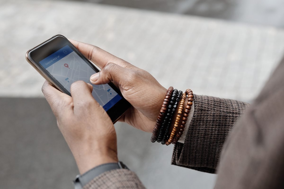 Close-up of hands navigating on a smartphone GPS app.