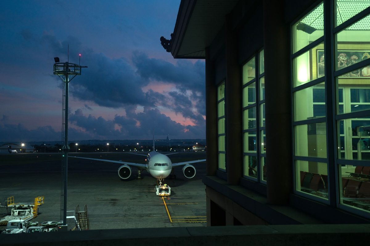 Airplane parked at a gate during twilight hours.