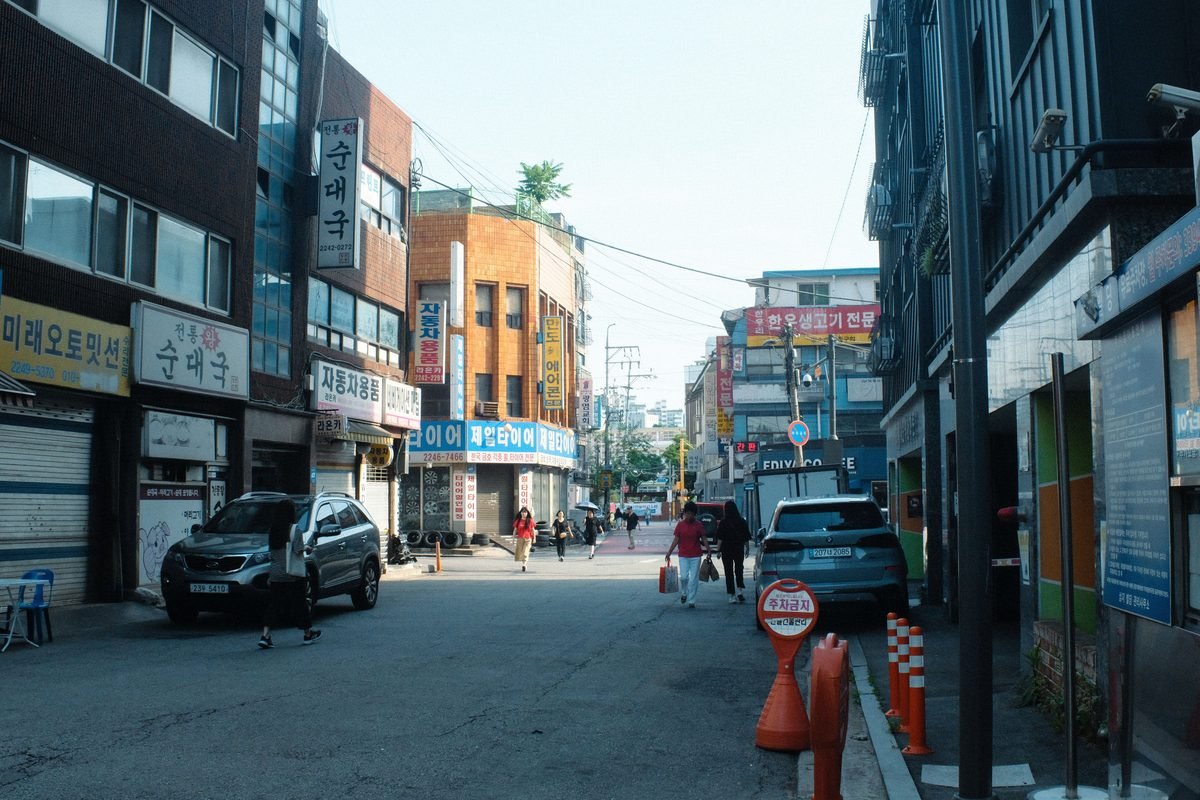 Urban street scene in Seoul with cars and buildings.