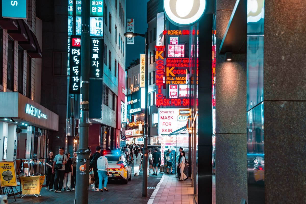 Vibrant night street in Myeongdong district of Seoul with illuminated signs.