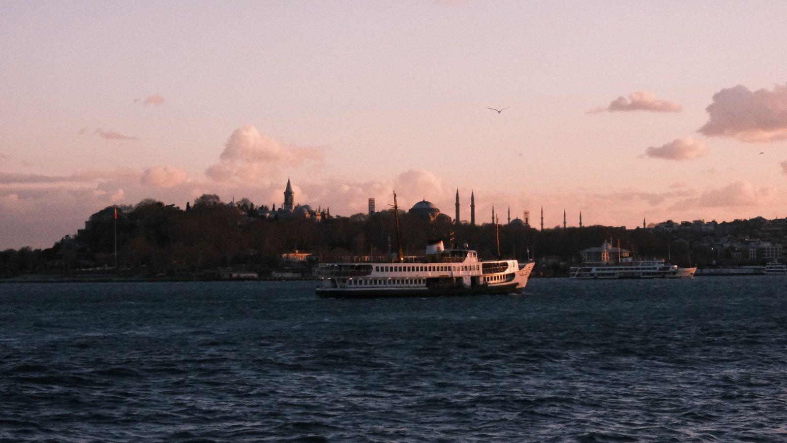 Scenic Istanbul view with ferry on Bosphorus during sunset.