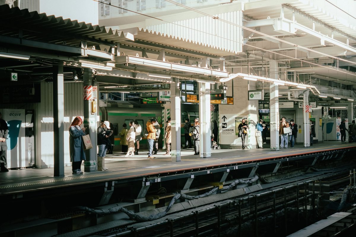 Commuters waiting at an urban train station platform in Japan